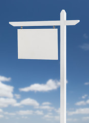 Image showing Blank Real Estate Sign Over A Blue Sky with Clouds.