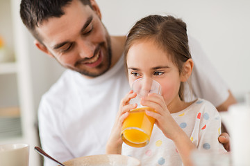 Image showing happy girl with father drinking juice at home