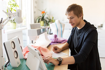 Image showing fashion designer with tablet pc working at studio