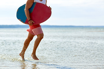 Image showing young man with skimboard on summer beach