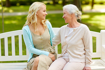 Image showing daughter with senior mother hugging on park bench