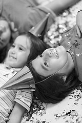 Image showing kids  blowing confetti while lying on the floor