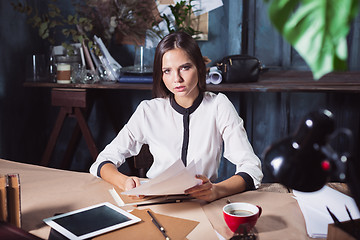 Image showing Young beautiful woman working with cup of coffee