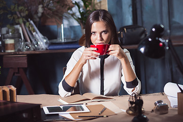 Image showing Young beautiful woman working with cup of coffee