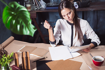 Image showing Young beautiful woman working with cup of coffee