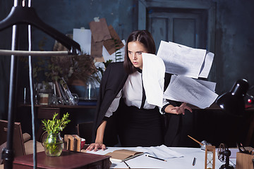 Image showing Young business woman throwing documents at camera.