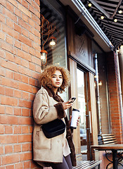 Image showing young pretty african american women drinking coffee outside in c