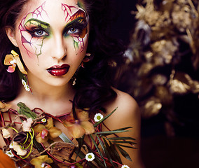 Image showing beauty woman with face art and jewelry from flowers orchids close up