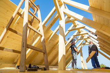 Image showing Builders at work with wooden roof construction.