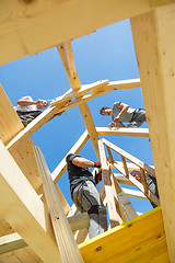 Image showing Builders at work with wooden roof construction.