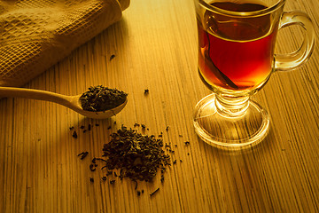 Image showing Brewing tea, spoon with tea leaves and cup of tea