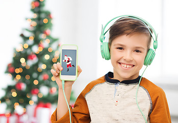 Image showing boy with smartphone and headphones at christmas