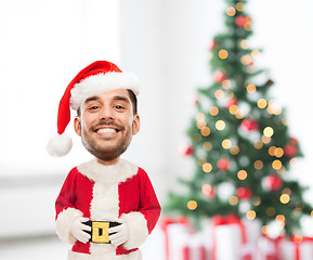 Image showing smiling man in santa costume over christmas tree