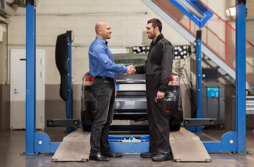 Image showing mechanic and customer shaking hands at car service