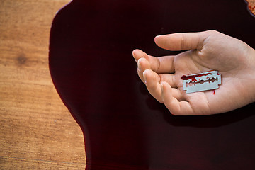 Image showing dead woman hand in blood on floor at crime scene