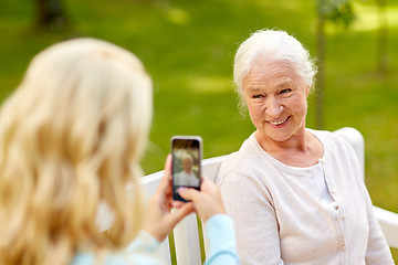 Image showing daughter photographing senior mother by smartphone