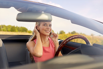 Image showing woman calling on smartphone at convertible car