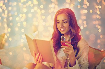 Image showing happy young woman reading book in bed at home