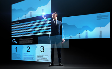 Image showing businessman with stock charts on virtual screens