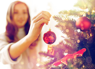 Image showing happy young woman decorating christmas tree