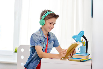 Image showing student boy in headphones reading book at home