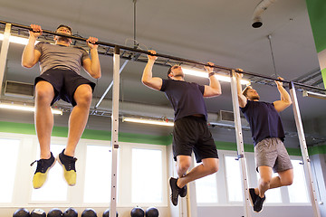 Image showing group of young men doing pull-ups in gym