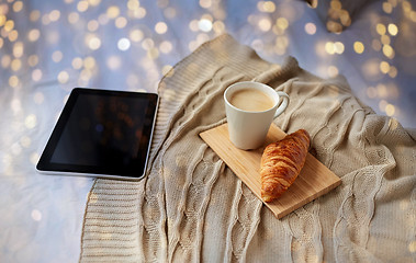 Image showing tablet pc, coffee and croissant on bed at home