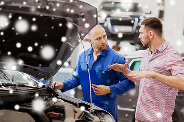 Image showing auto mechanic with clipboard and man at car shop