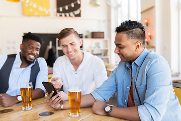 Image showing male friends with smartphone drinking beer at bar