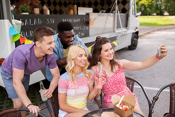 Image showing happy young friends taking selfie at food truck