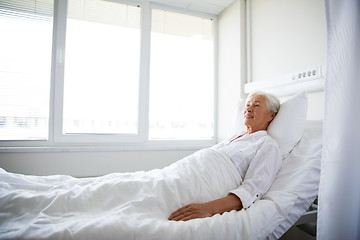 Image showing smiling senior woman lying on bed at hospital ward