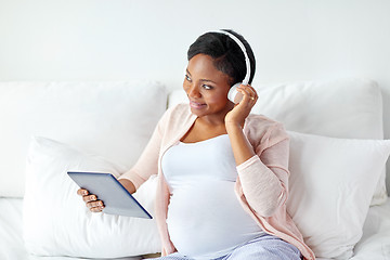 Image showing pregnant woman in headphones with tablet pc