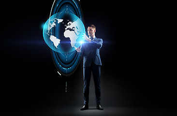 Image showing businessman with earth hologram over black