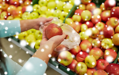 Image showing woman with bag buying apples at grocery store