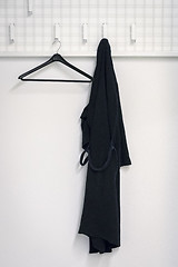 Image showing a black bathrobe is hanging at the wardrobe