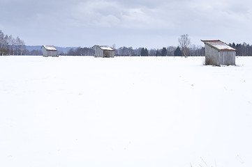 Image showing a snow covered landscape with three huts