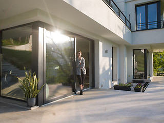 Image showing woman drinking coffee in front of her luxury home villa