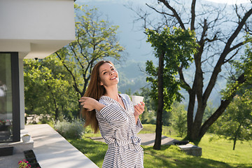 Image showing woman in a bathrobe enjoying morning coffee