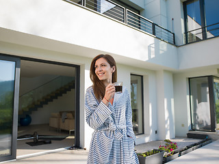 Image showing woman in a bathrobe enjoying morning coffee