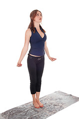 Image showing Slim woman standing doing yoga