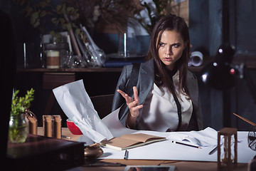 Image showing Young business woman throwing documents at camera.