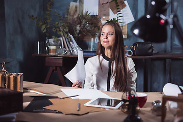 Image showing Young frustrated woman working at office desk in front of laptop