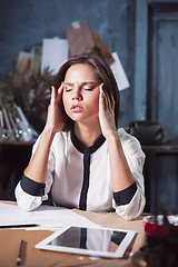 Image showing Young frustrated woman working at office desk in front of laptop