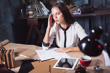 Image showing Young frustrated woman working at office desk in front of laptop