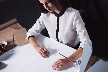 Image showing Architect working on drawing table in office