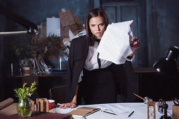 Image showing Young business woman throwing documents at camera.