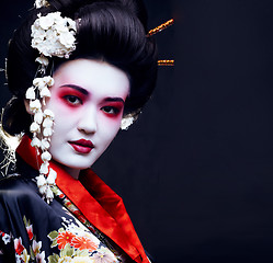 Image showing young pretty geisha in kimono with sakura and decoration