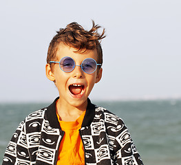 Image showing cute little boy at seacoast in fashion clothers and blue glasses