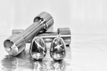 Image showing Metal dumbbells and steel eggs, the concept of sports training and the achievement of muscle strength