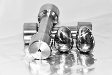 Image showing Metal dumbbells and steel eggs, the concept of sports training and the achievement of muscle strength